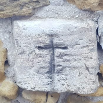 Cruz tallada en una de las piedras de la muralla